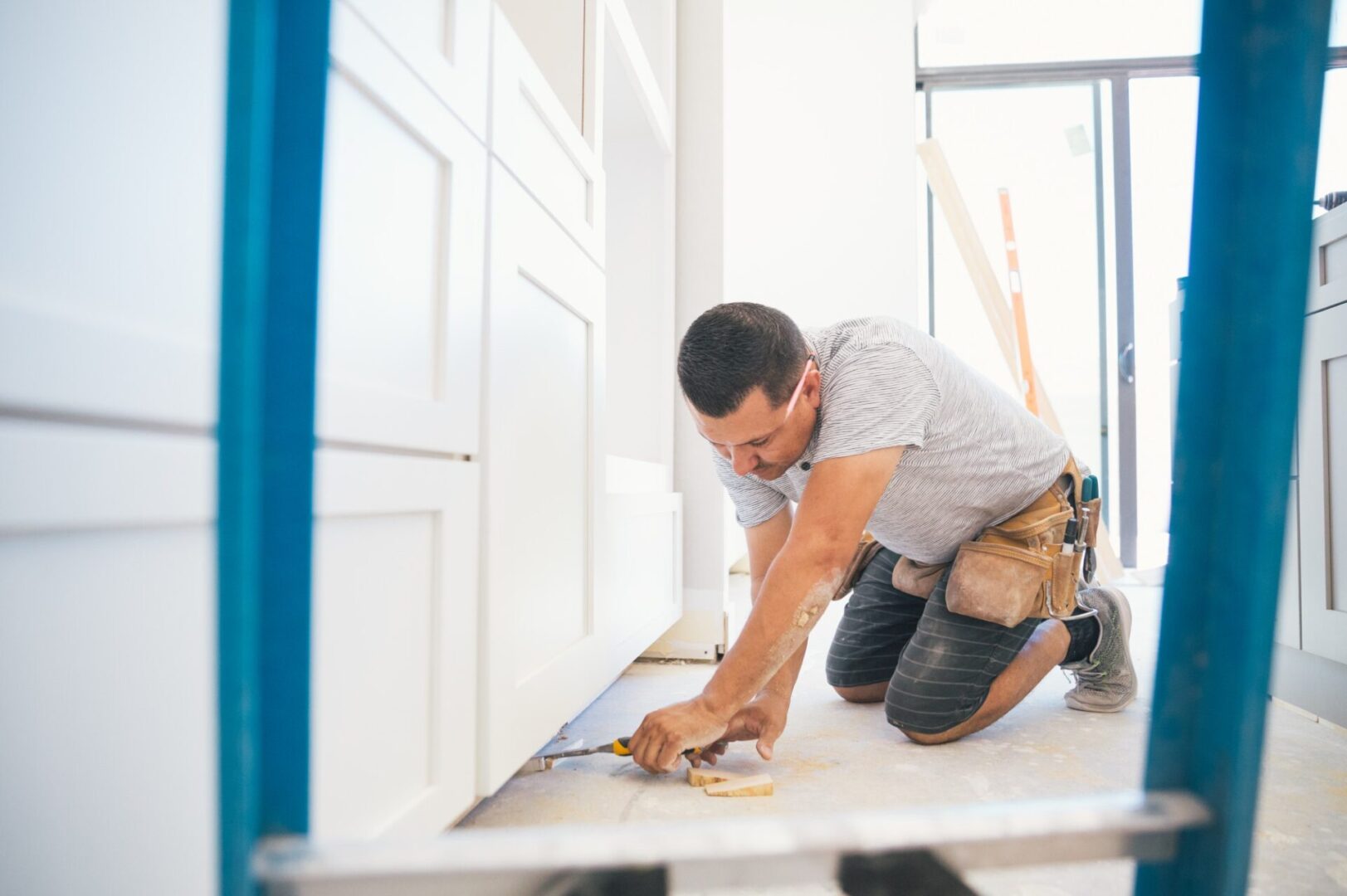 Worker installing cabinets in a kitchen.