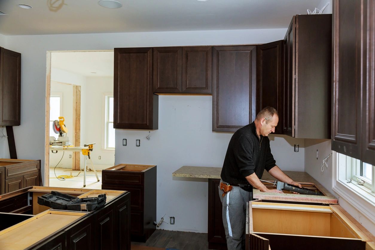Man assembling kitchen cabinets in a modern home.